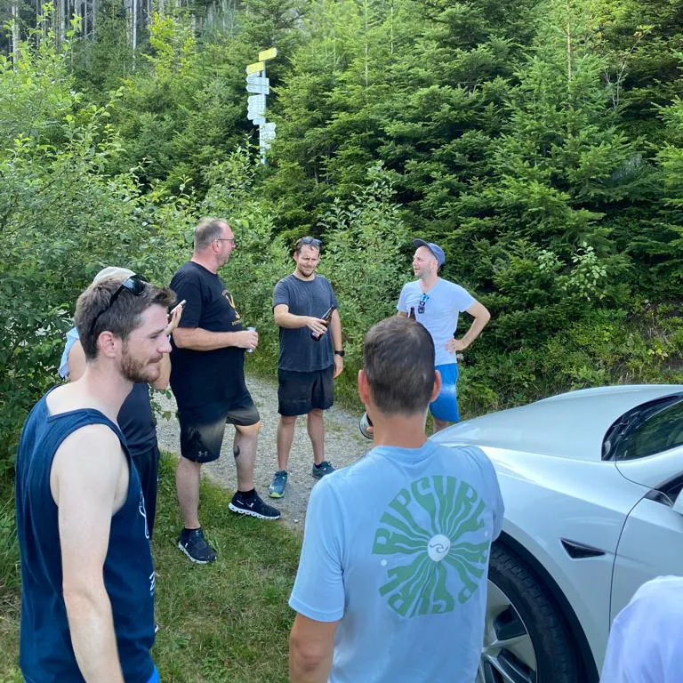 Team Building Regli Offsite Event Wärmepumpe Mitarbeiter in Wald mit Tesla Elektroauto Wandern
