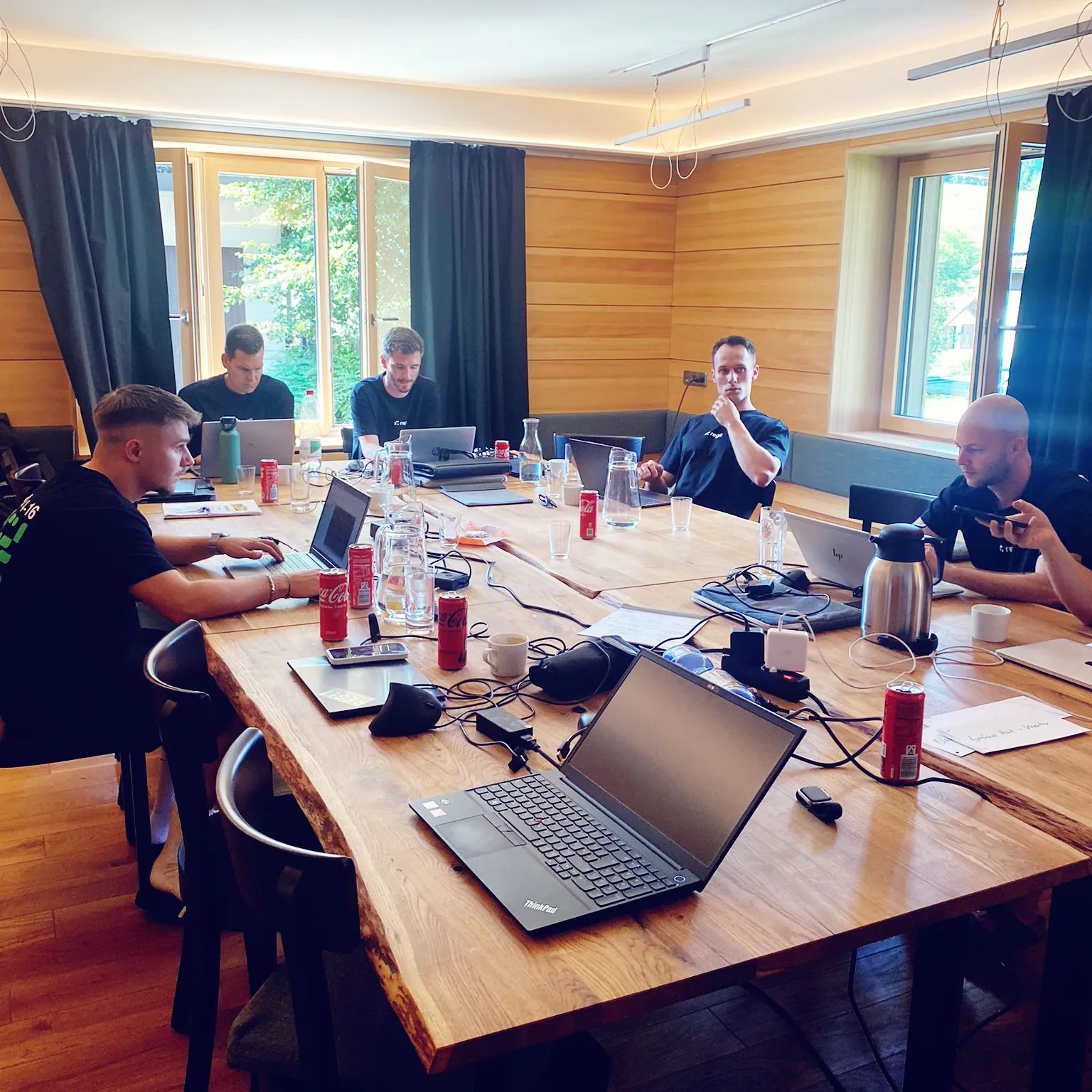 Team Building Regli Offsite Event Wärmepumpe Mitarbeiter in Raum mit Tischen 