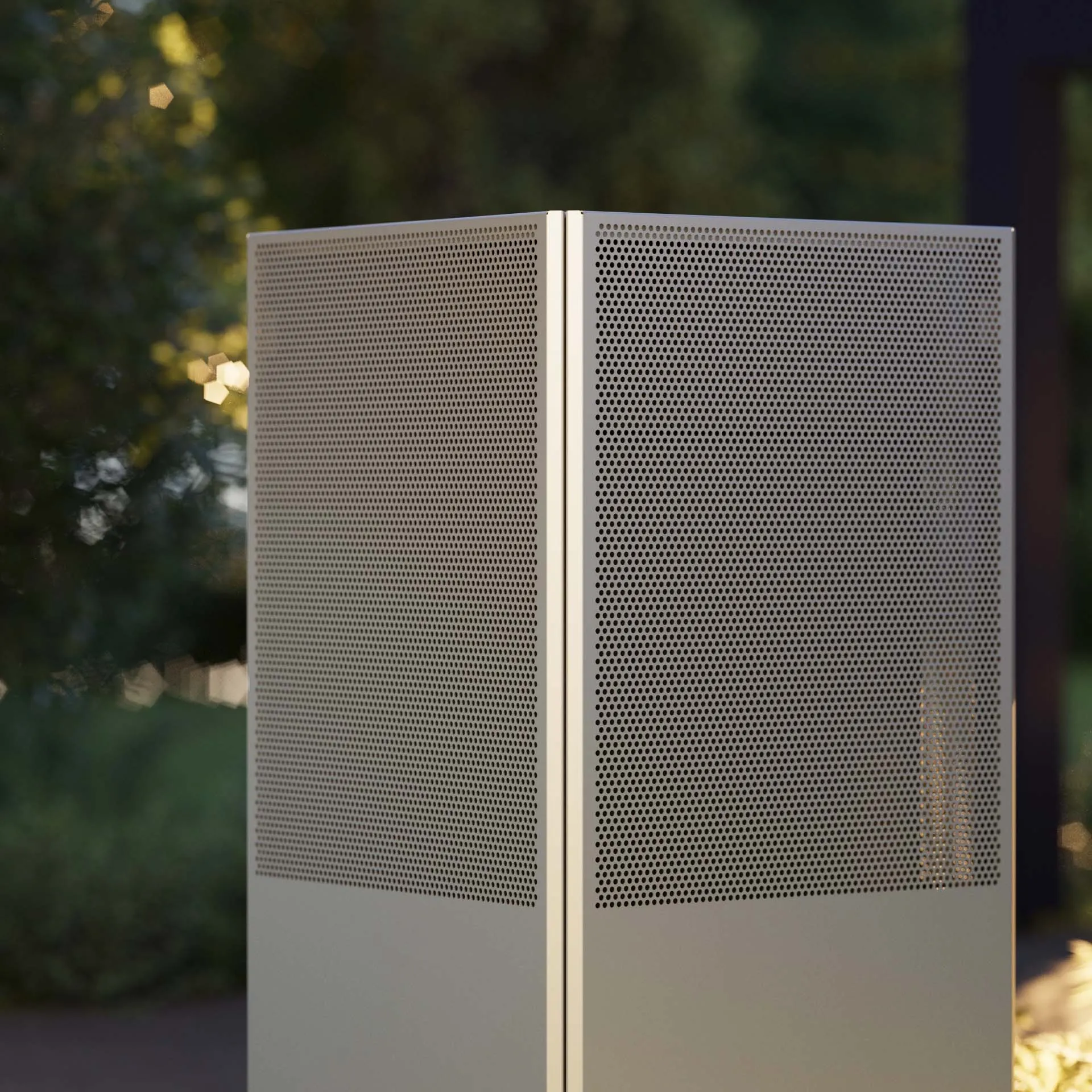 silver heat pump NovaAir side view in garden in front of green trees