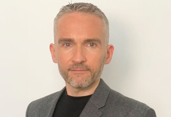 Steve Burrows, one of the two founders of Agility Arabia. He is smiling, and is dressed in a grey jacket over a black shirt