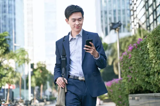 a man in a suit holding a phone while walking