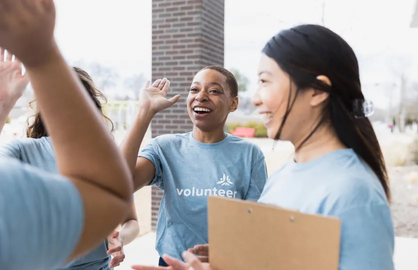 Group of women volunteers exchanging high-fives.