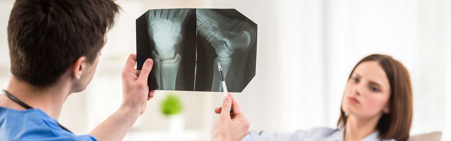 a woman holding up an x - ray image to a man