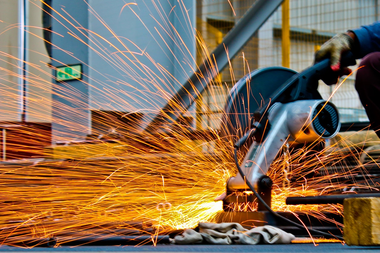 Person using a chop saw to cut metal and sparks flying