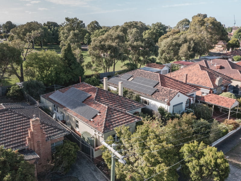 A neighbourhood with red tiled roofs. Only two houses have solar panels installed