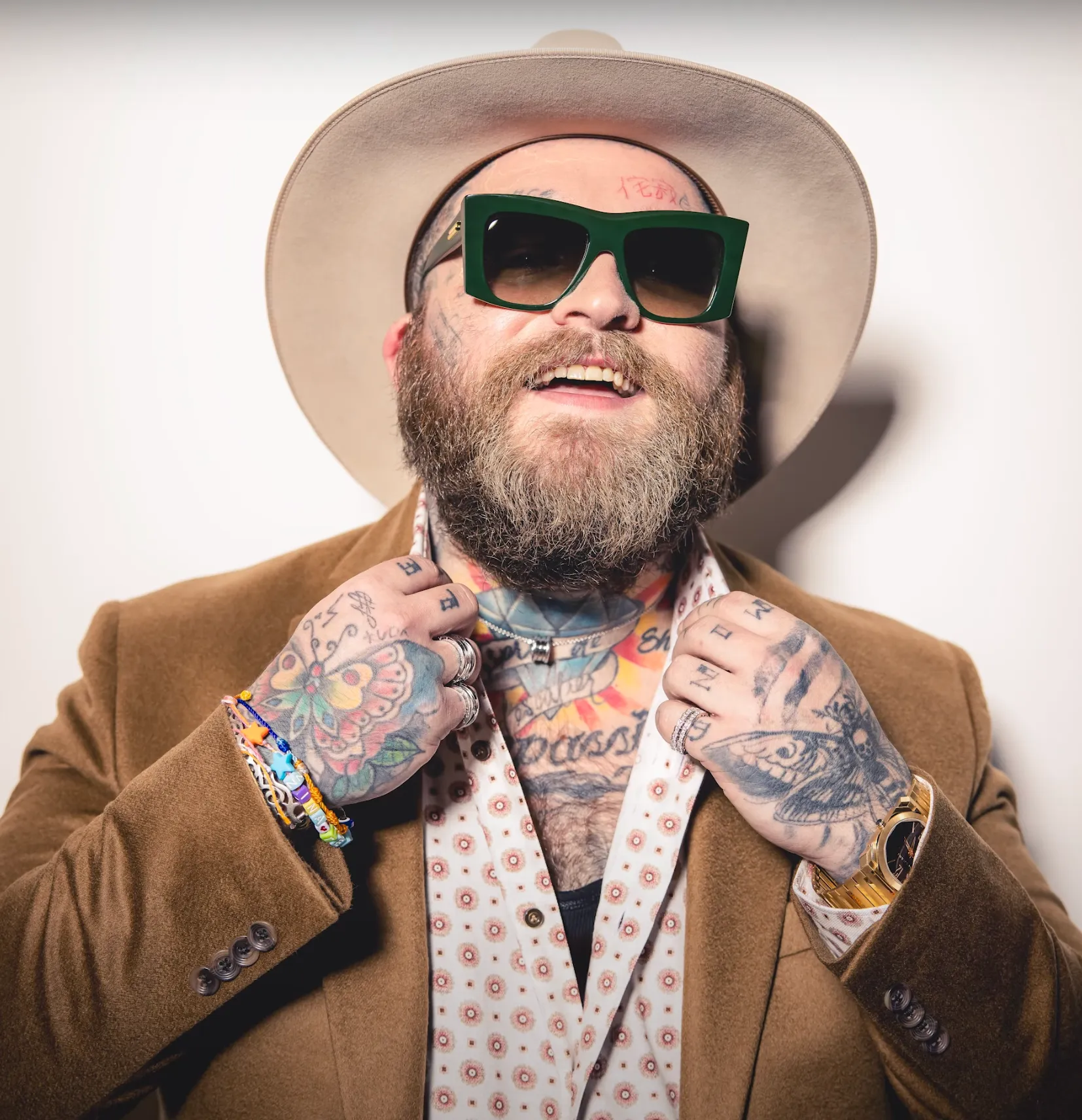 Portrait of Teddy Swims wearing a brown suit, hat, and glasses for the Dolce Magazine photoshoot