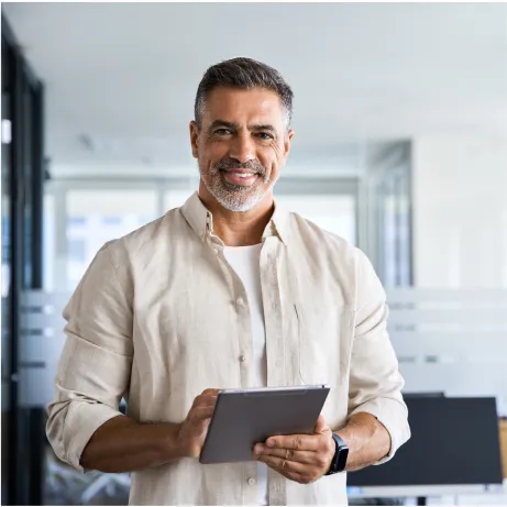 A man in a white shirt is holding a tablet.