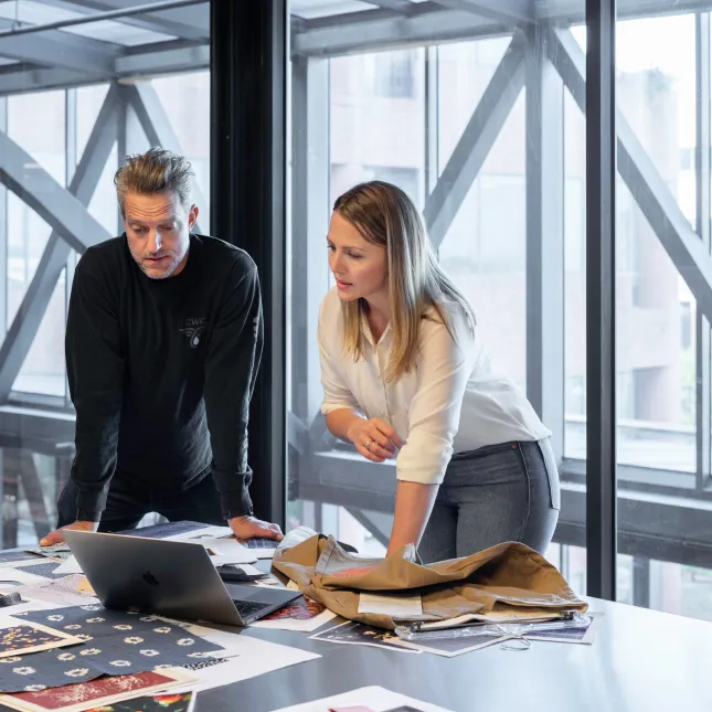 a man and a woman looking at papers on a table