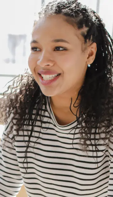 A woman smiling in a striped shirt