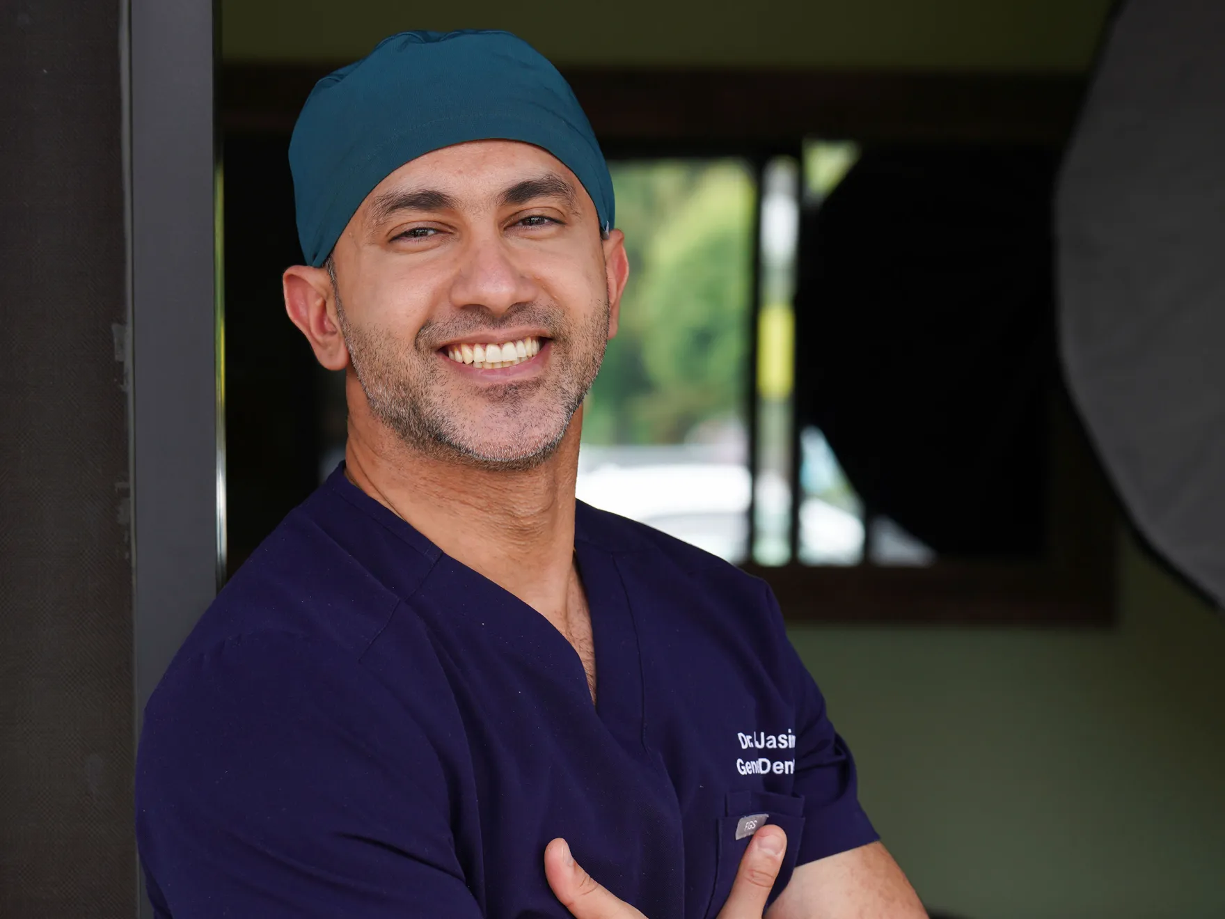 a man in scrubs is smiling for the camera