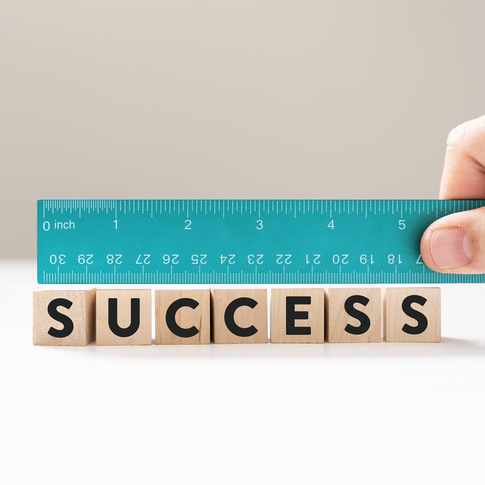 Measure success word using blue ruler, representing a review, evaluation, or assessment of an employee.