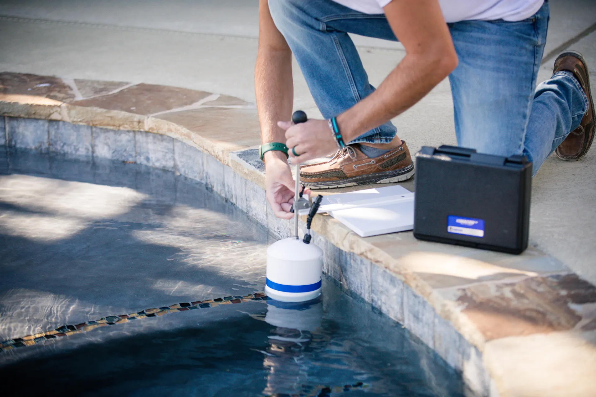 A Gary Pools employee using equipment to test for pool leaks