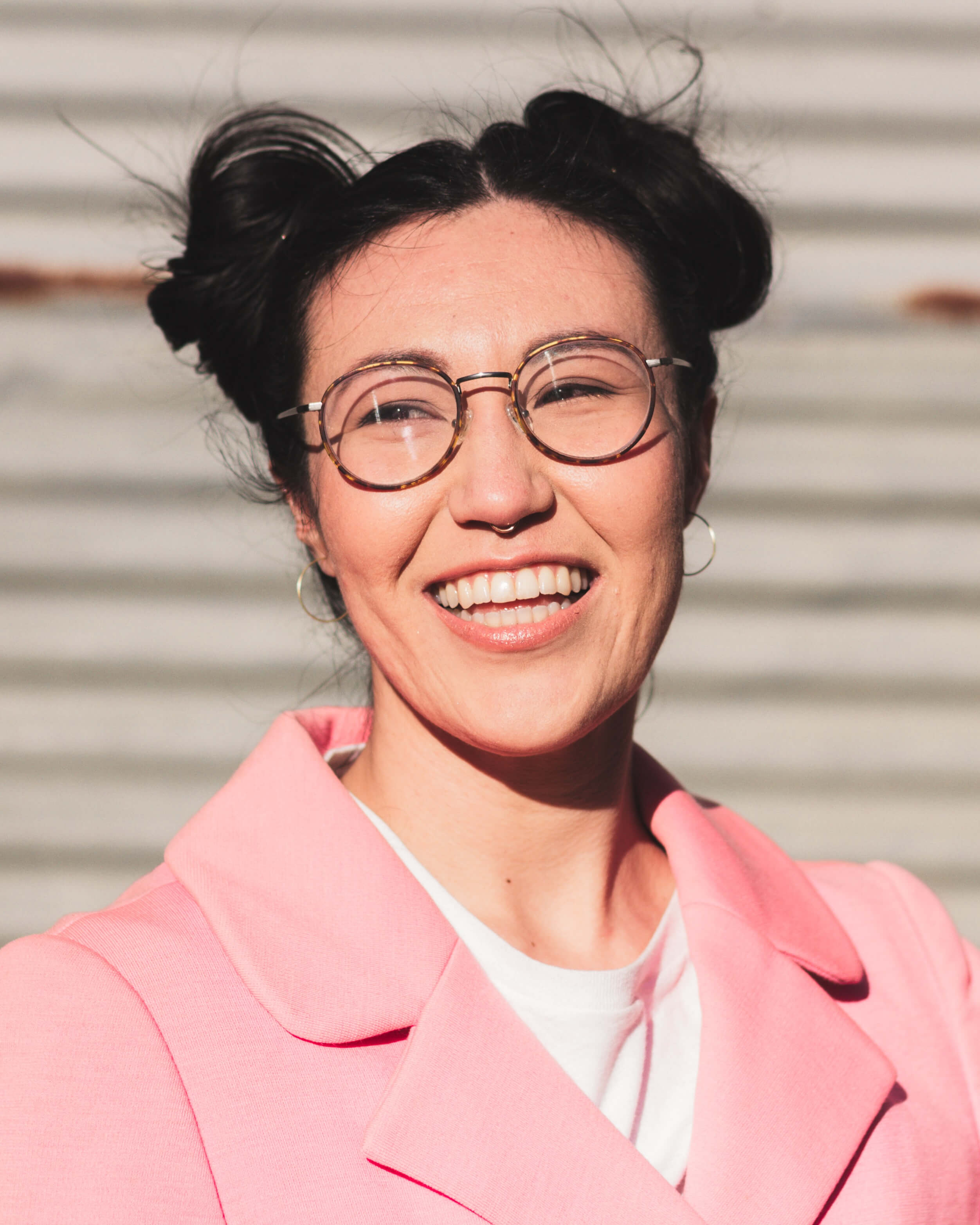 a woman wearing glasses and a pink coat