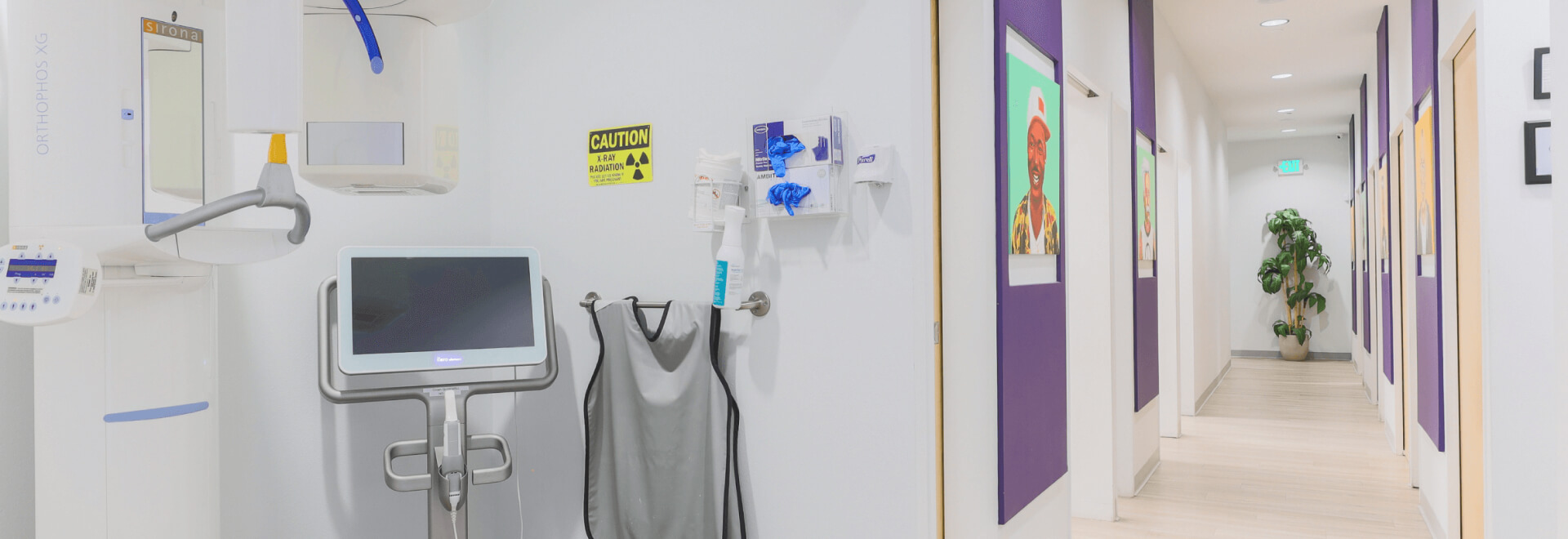 a dental clinic hallway with a monitor and medical equipment