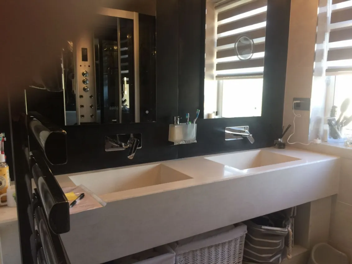 White concrete sink with shelf underneath & Black splash back on the wall