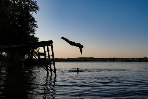 Diving in the water; A member of the organization Repair Together enjoying free time after a long day of work in the Chernihiv region. September 2023. Chernihiv Ukraine
