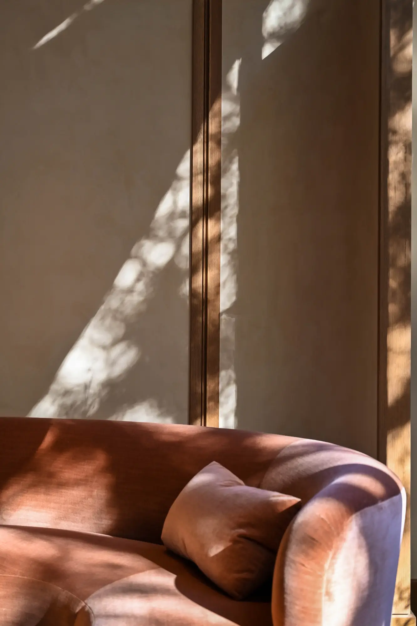 a velvet couch sitting in the sunlight
