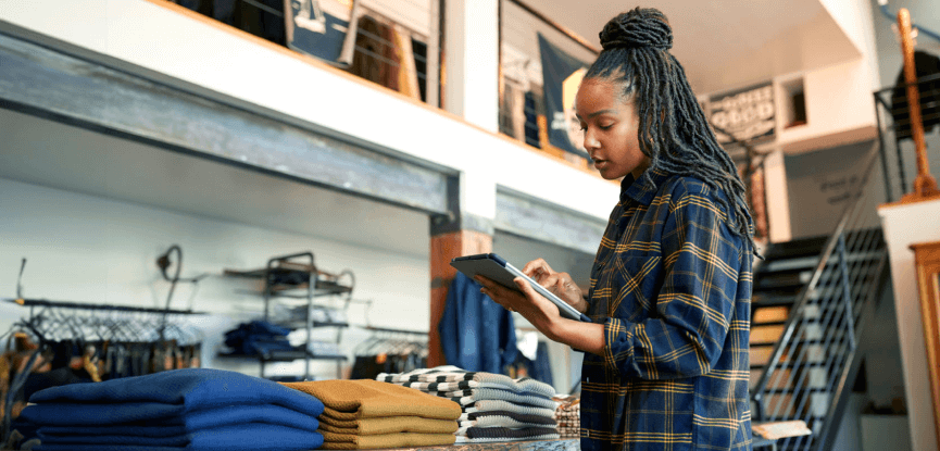 Woman looking at a tablet to review employee training workflows from DeepHow. 