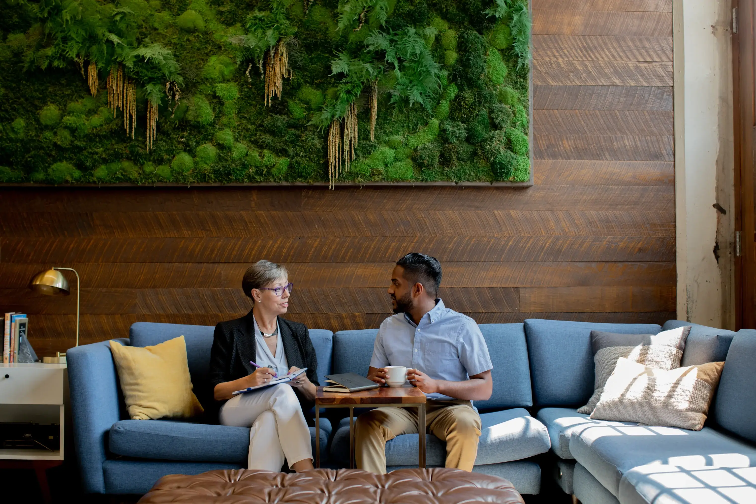 Two people sitting on a blue couch. 