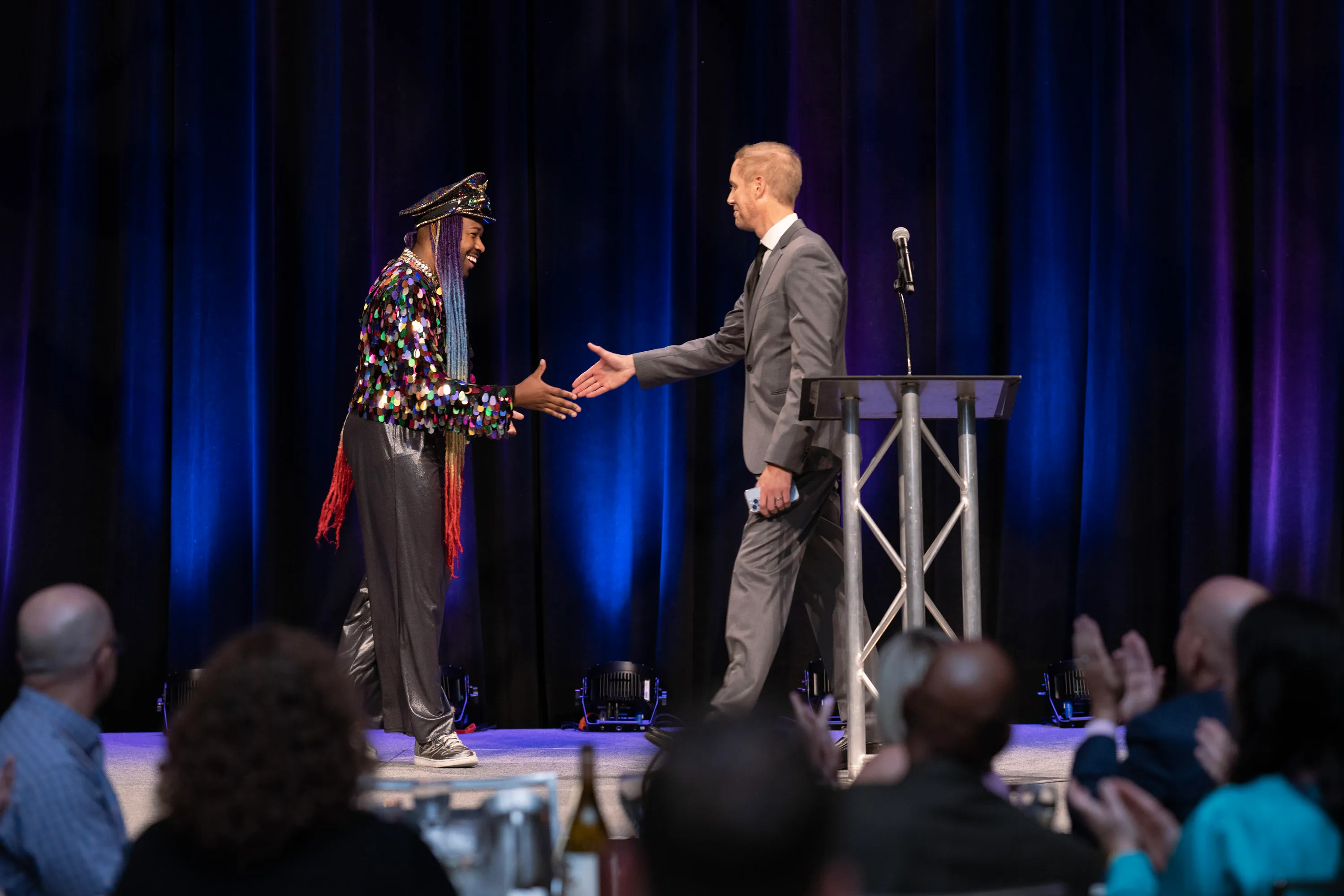 a man and woman shaking hands on stage