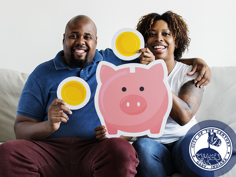 Happy financial literacy couple, holding oversized piggy bank and coins.