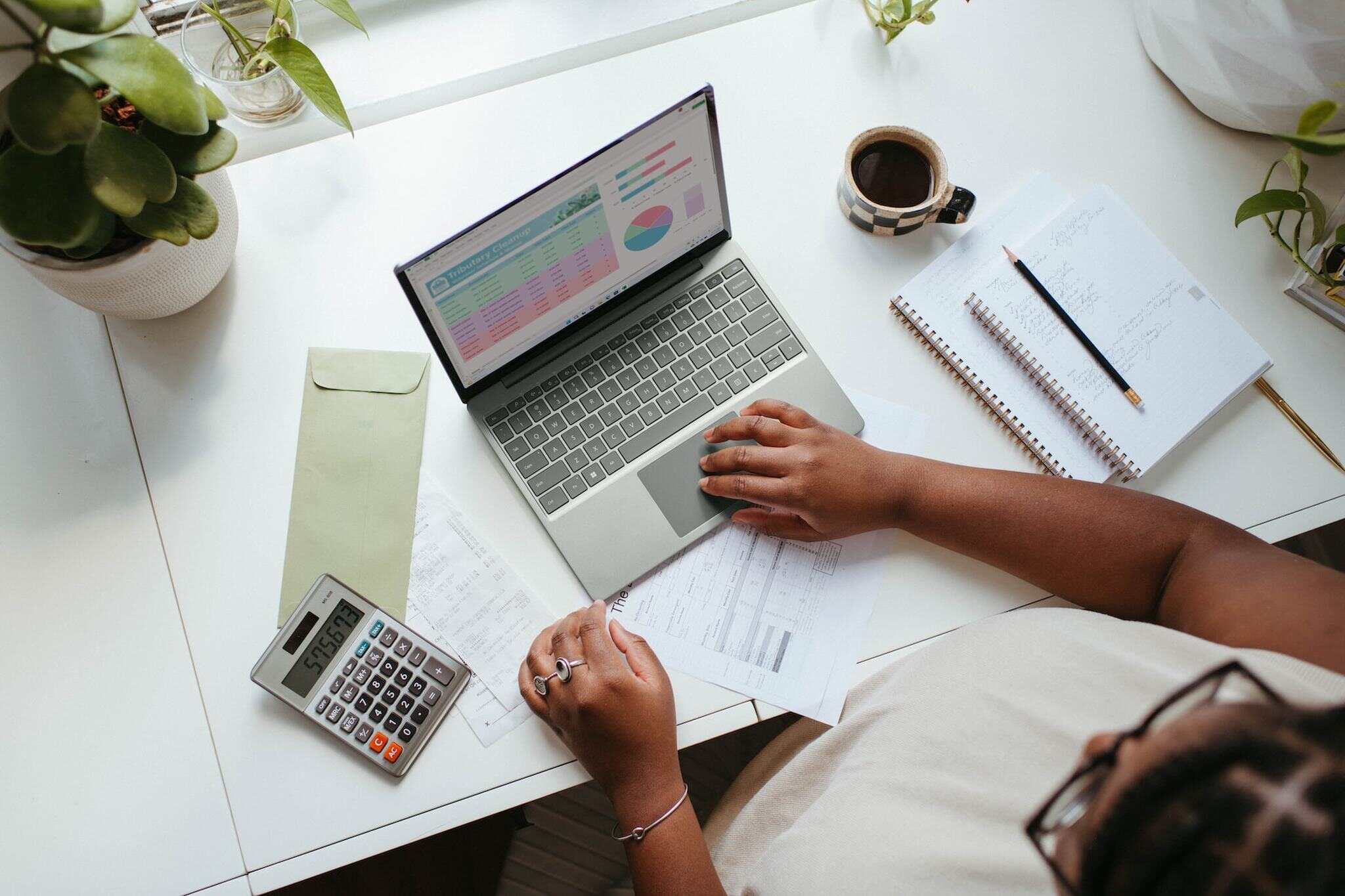 a person using calculator and MacBook