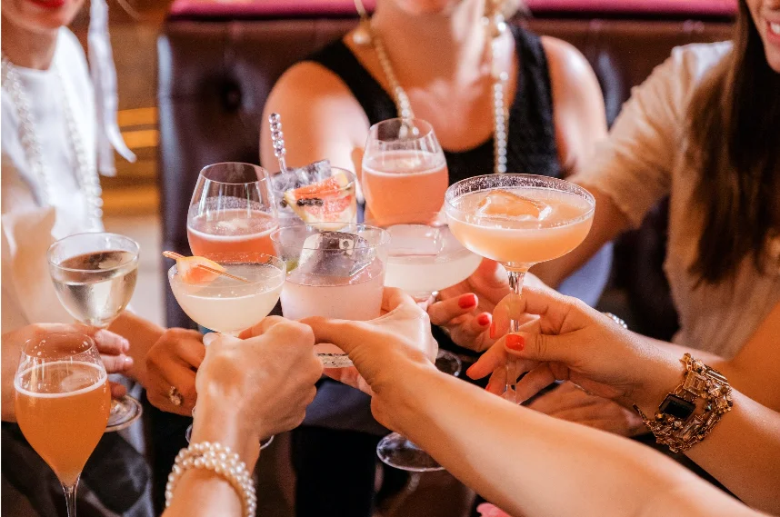 A group of people holding up glasses of drinks.