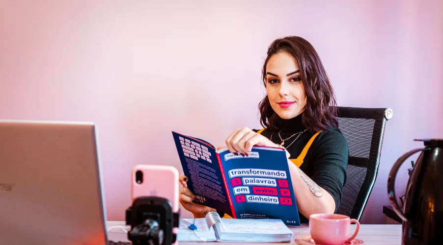 A person sitting at a desk reading a book.