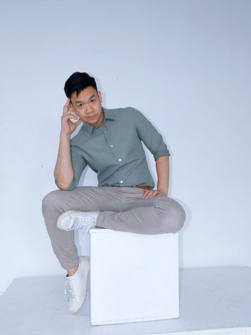 Matheus Ting, Asian actor, singer, dancer, photographed in a studio with a white background on a plinth.