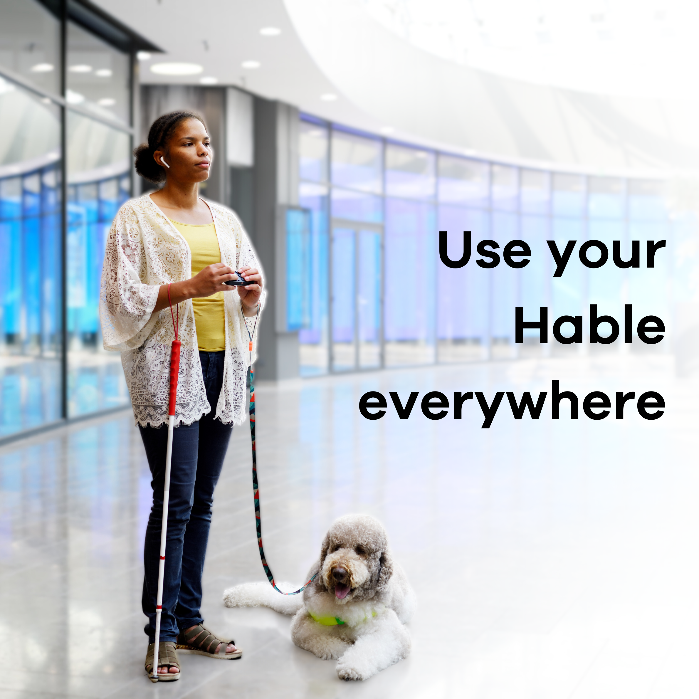 Image of a woman holding the Hable One and her guide dog sitting next to her. The text reads: Use your Hable Everywhere.