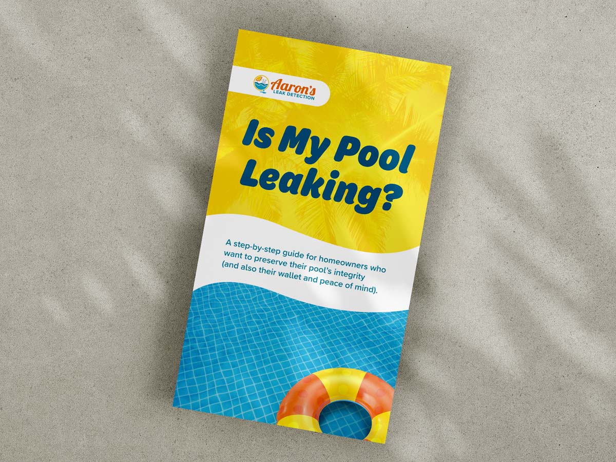 "Is My Pool Leaking?" guide laying on a concrete background with palm tree shadows falling on it