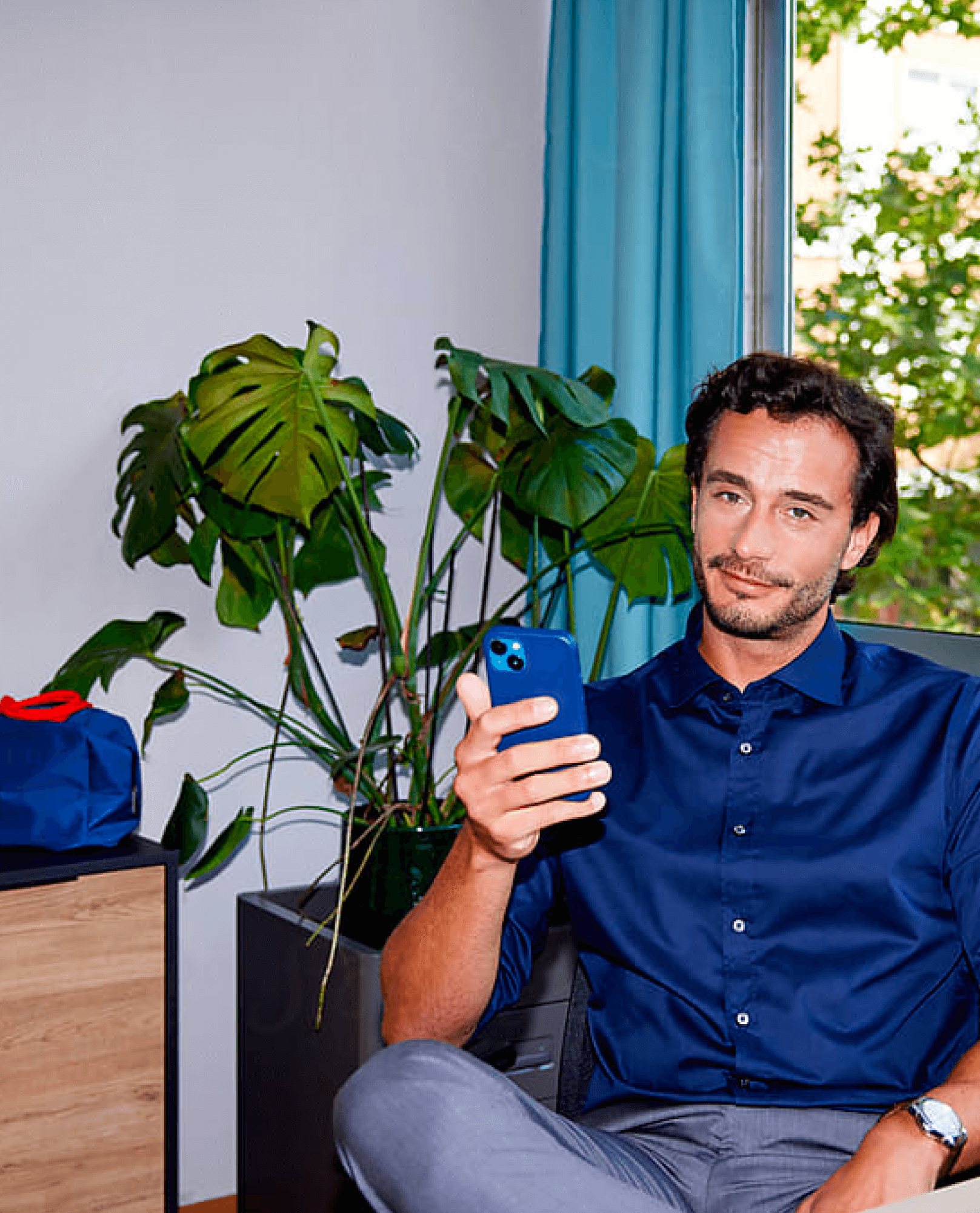 man looking at camera, holding phone