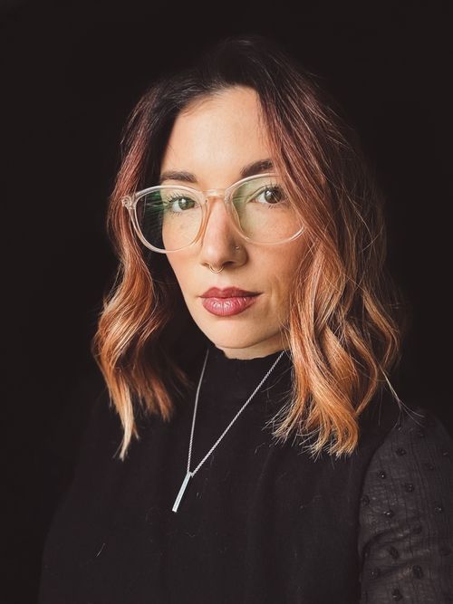 A headshot of Breanna Darby with a black background